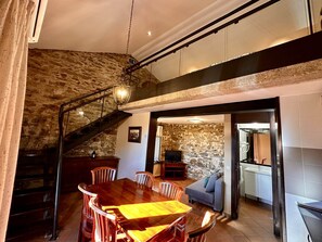 Enjoy meals in this dining area with a large table and six chairs, featuring a staircase and a chandelier.