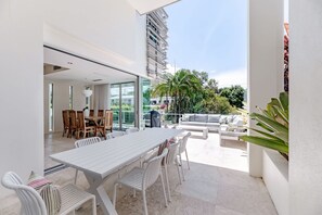 An open-plan living area with a dining table, chairs, and a sofa.