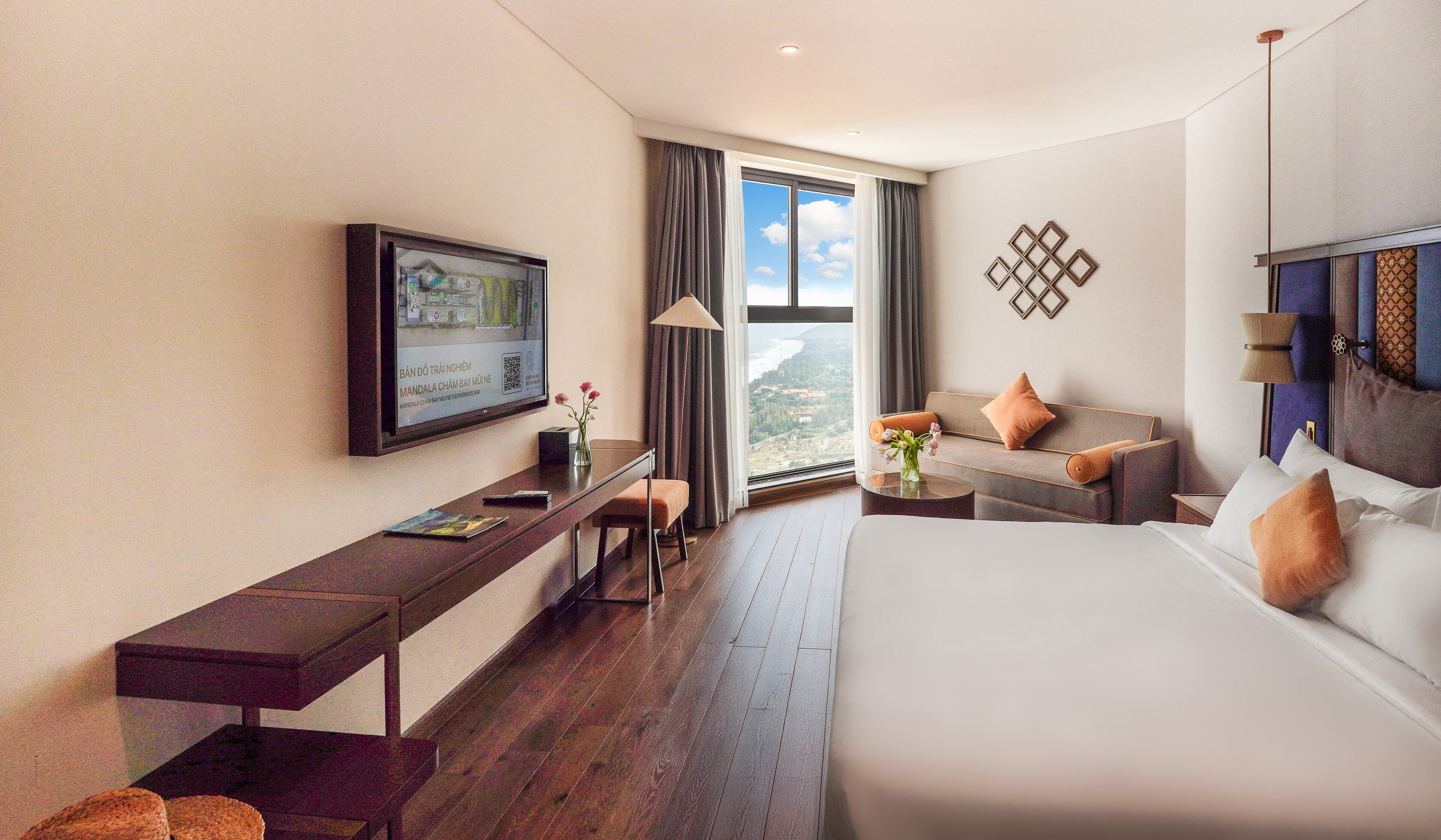 Ein Hotelzimmer mit Bett, einer Couch, einem Schreibtisch und einem Fernseher.