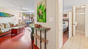 Un salon avec un canapé, une table basse et un tableau accroché au mur.
