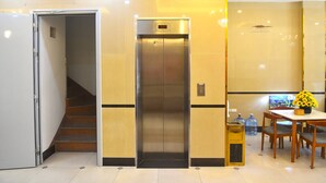 An elevator, a staircase, and a dining area with a table and chairs. - Thanh Hang Hotel near Emerald My Dinh (Hanoi)