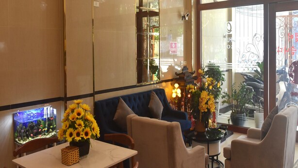 A cozy seating area with a table, chairs, and a fish tank. - Thanh Hang Hotel near Emerald My Dinh (Hanoi)