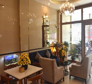 A cozy seating area with a table, chairs, and a fish tank. - Thanh Hang Hotel near Emerald My Dinh (Hanoi)