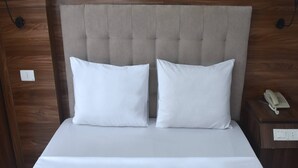 A neatly made bed with two pillows and a wooden headboard. - Thanh Hang Hotel near Emerald My Dinh (Hanoi)