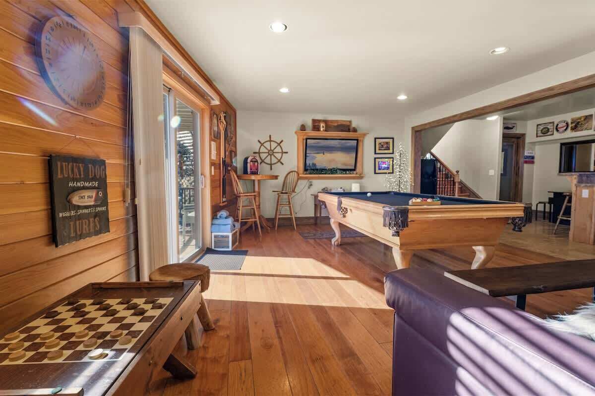 Una habitación acogedora con mesa de billar, banco de madera y tablero de ajedrez.