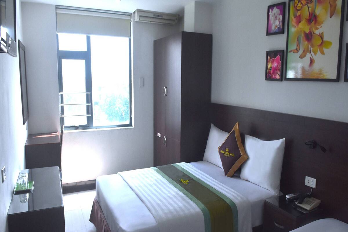 Une chambre d’hôtel avec un lit, une table de chevet et une fenêtre.