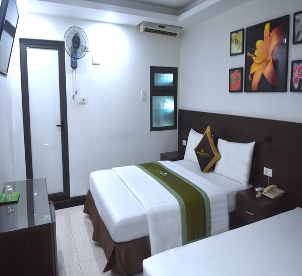 A hotel room with a bed, bedside table, and a wall-mounted fan. - Sao Hotel Nguyen Ngoc Vu (Hanoi)