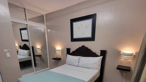 A bedroom with a bed, bedside lamps, a mirror, and a framed picture on the wall. - Modern 2 Bedroom Apartment 5b in Puerto Plata (Puerto Plata)
