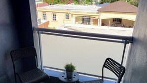 A balcony with two chairs, a small table, and a potted plant. - Modern 2 Bedroom Apartment 5b in Puerto Plata (Puerto Plata)