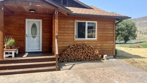 Una casa in legno con un portone, una finestra e un piccolo portico.