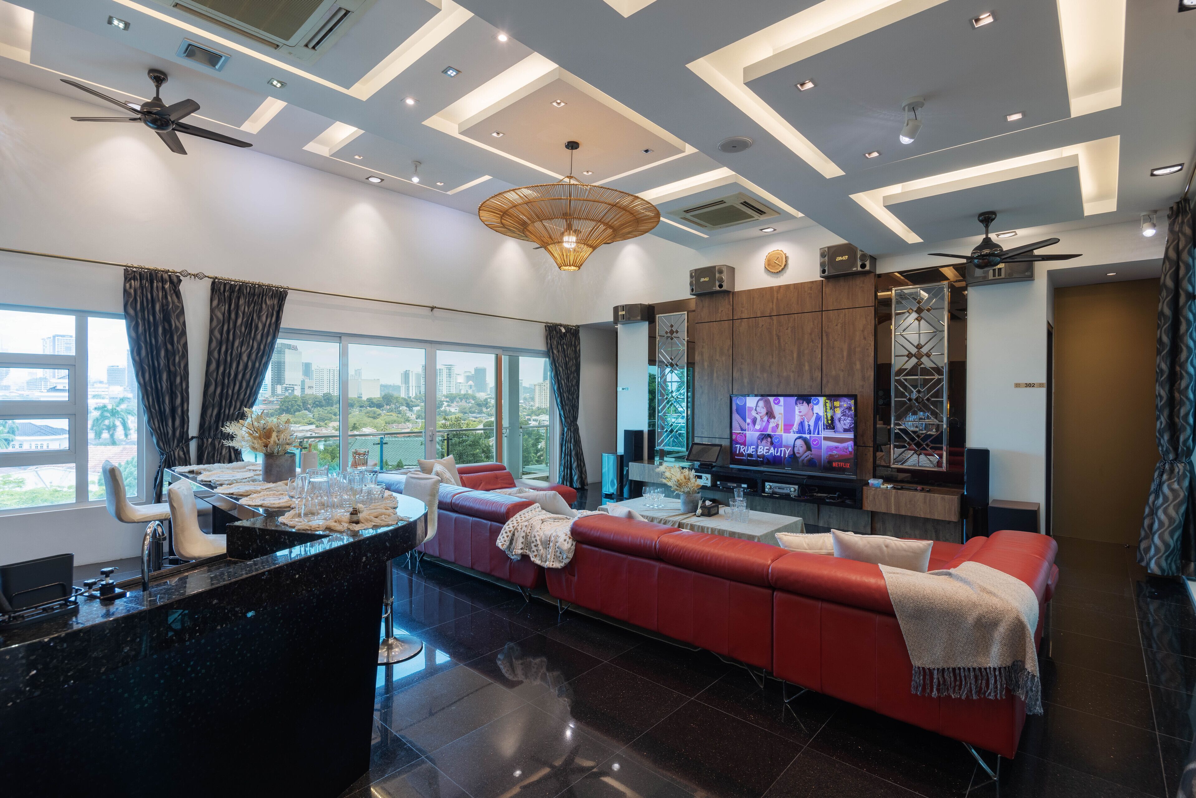 A modern living room with a red sofa, a TV, and a city view.