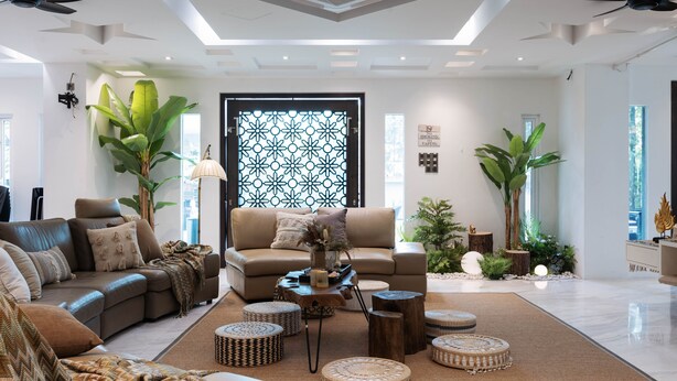 A modern living room with a sectional sofa, a coffee table, and decorative plants. - 25000sqft Grand Luxe Villa PJ 13BR 42Pax (Petaling Jaya)