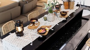 A dining table with a woven placemat, a candle, and various dishes. - 25000sqft Grand Luxe Villa PJ 13BR 42Pax (Petaling Jaya)
