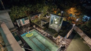 An aerial view of a rooftop pool area with a geometric design, surrounded by trees and modern architecture. - 25000sqft Grand Luxe Villa PJ 13BR 42Pax (Petaling Jaya)