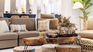 A modern living room with a sofa, coffee table, and decorative items. - 25000sqft Grand Luxe Villa PJ 13BR 42Pax (Petaling Jaya)