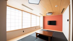 A room with tatami mat flooring, a wooden ceiling, a television on the wall, and a small table. - Welina Premier Osaka Namba (Osaka)
