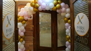 Ein Durchgang, geschmückt mit einer Ballondekoration und einem Schild mit der Aufschrift '19 HRS cafe & bistro'.