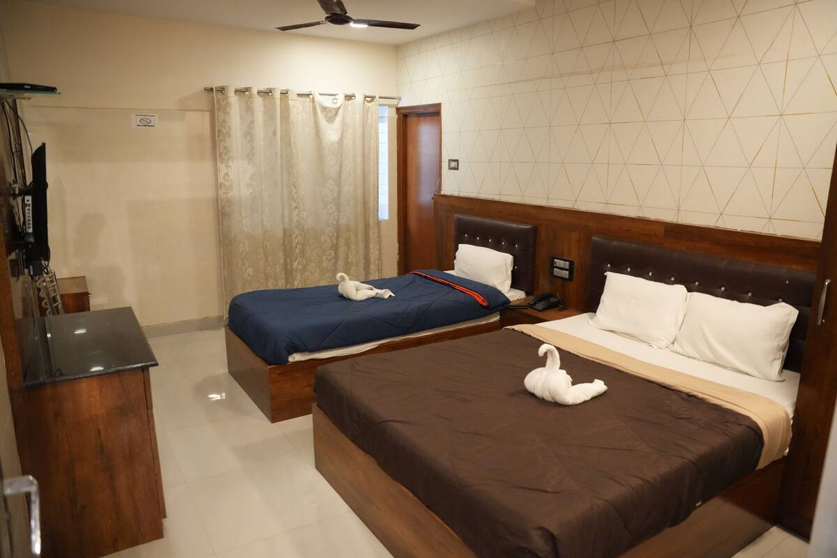 Habitació d'hotel amb dos llits, una escriptori i zona de banyera.