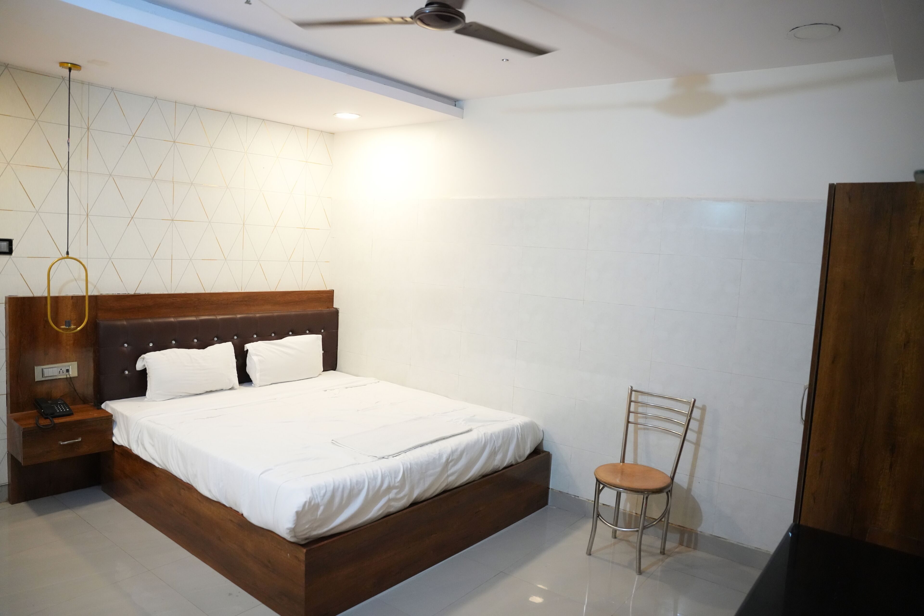 Un dormitorio moderno con una cama de madera, una mesita de noche, una silla y un armario.