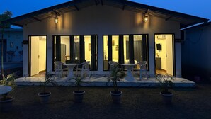 A two-story building with a flat roof and a balcony. There are two doors on the ground floor, each leading to a room with a bed and a chair. The building has a number '401' on the wall. - Six Seasons Resort (Kaladhungi)