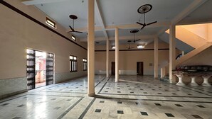 A spacious hall with marble flooring, multiple ceiling fans, and large windows allowing natural light. - Six Seasons Resort (Kaladhungi)