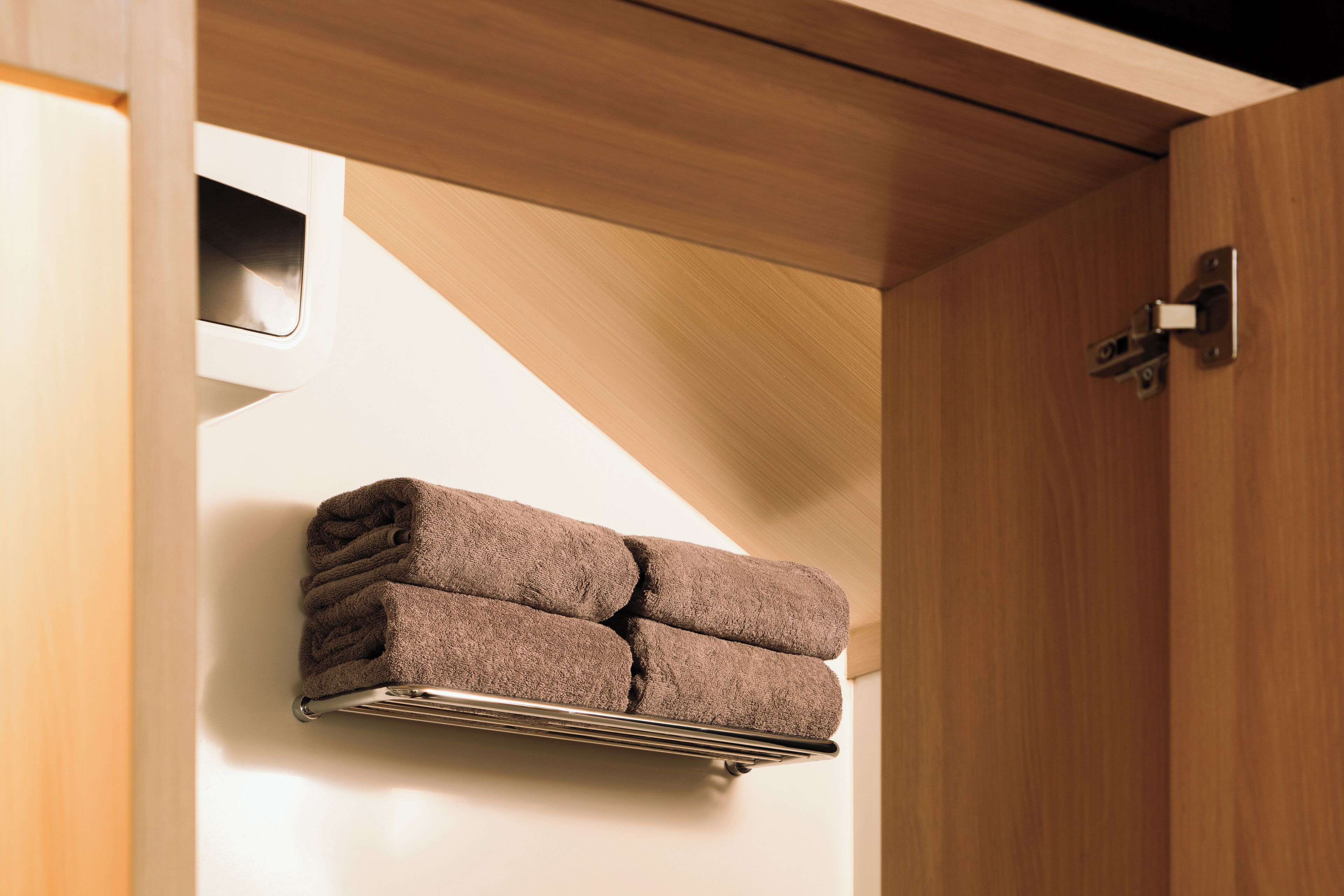 A towel rack with three towels in a modern bathroom setting.