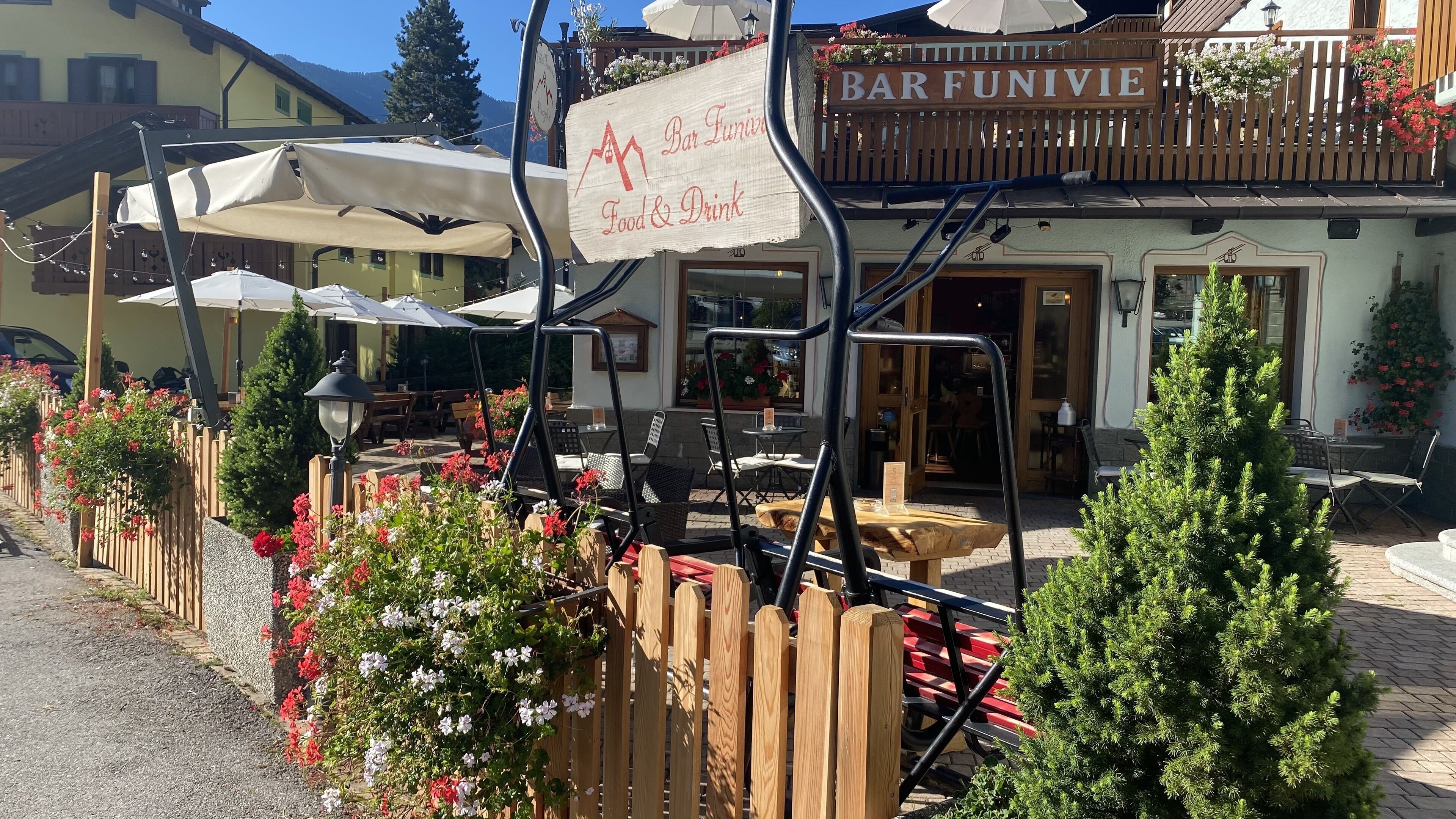 A restaurant named BAR FUNIVIE with outdoor seating and a sign indicating food and drink services.