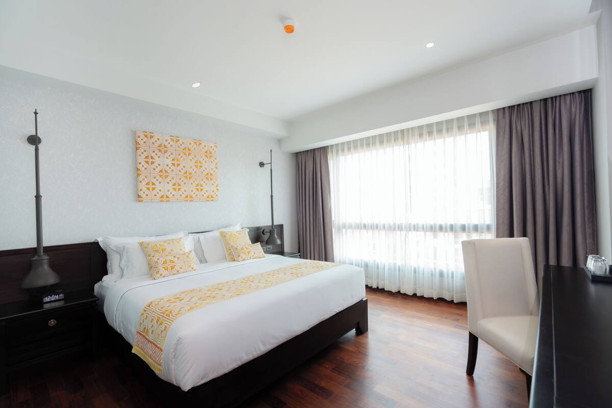 Une chambre d’hôtel moderne avec un grand lit, un bureau et une chaise.