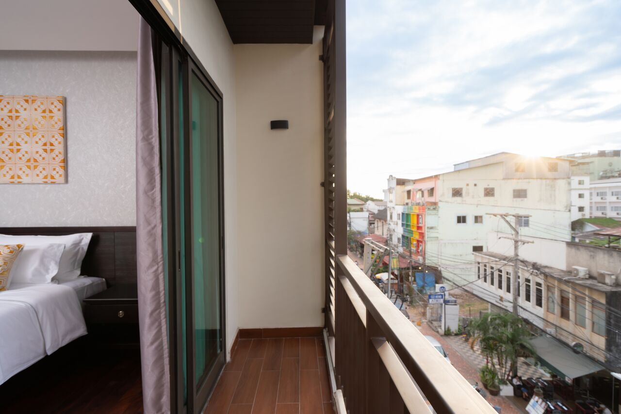 A balcony with a bed and a view of the city.