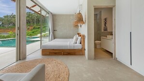 Een moderne slaapkamer met een grote glazen deur naar een zwembad, een houten bed en een minimalistische badkamer.