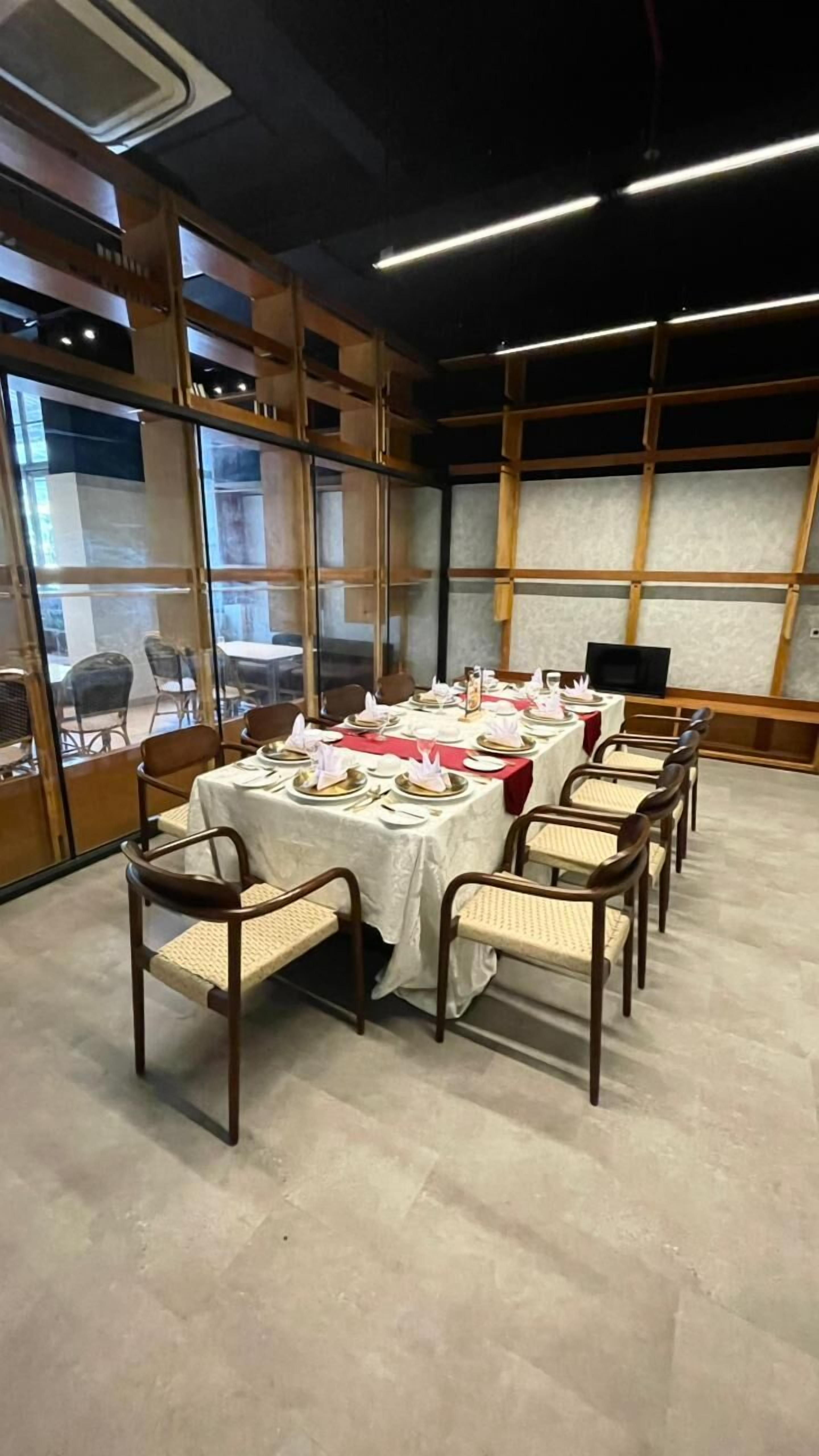 Een eethoek met een lange tafel gedekt voor een maaltijd, omringd door stoelen.
