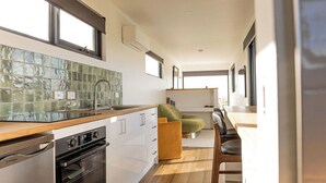 Una cocina moderna con un amplio ventanal, horno empotrado y encimera de madera.