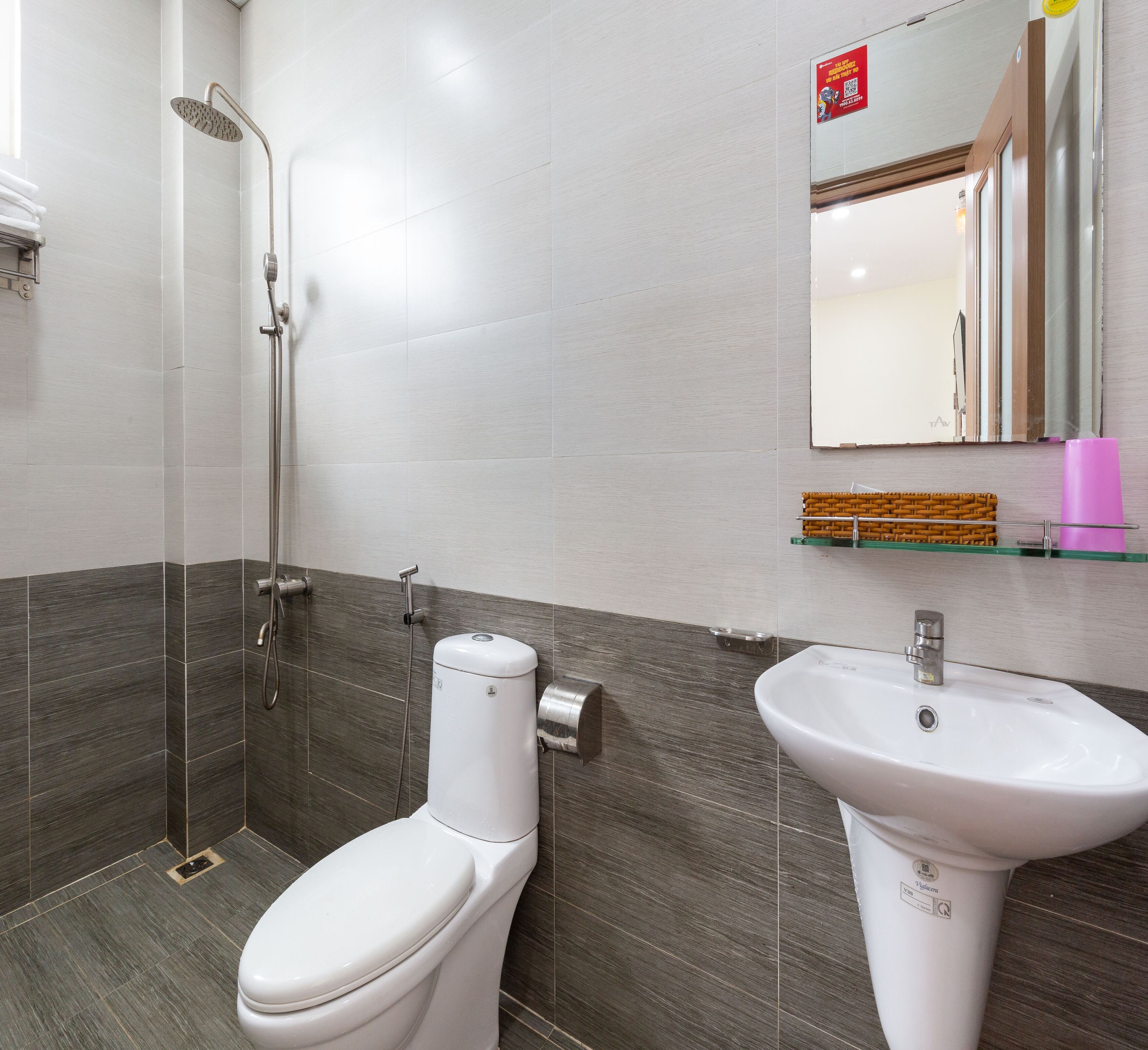 Une salle de bain moderne équipée d’une douche, de toilettes et d’un lavabo.