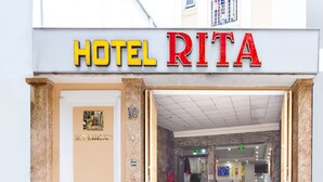 The entrance to Hotel Rita with a marble facade, a reception desk, and a visible phone number. - Rita Hotel (Ho Chi Minh City)