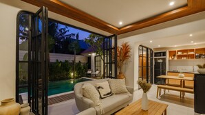 Un salon moderne avec un canapé, une table basse et une vue sur une piscine.