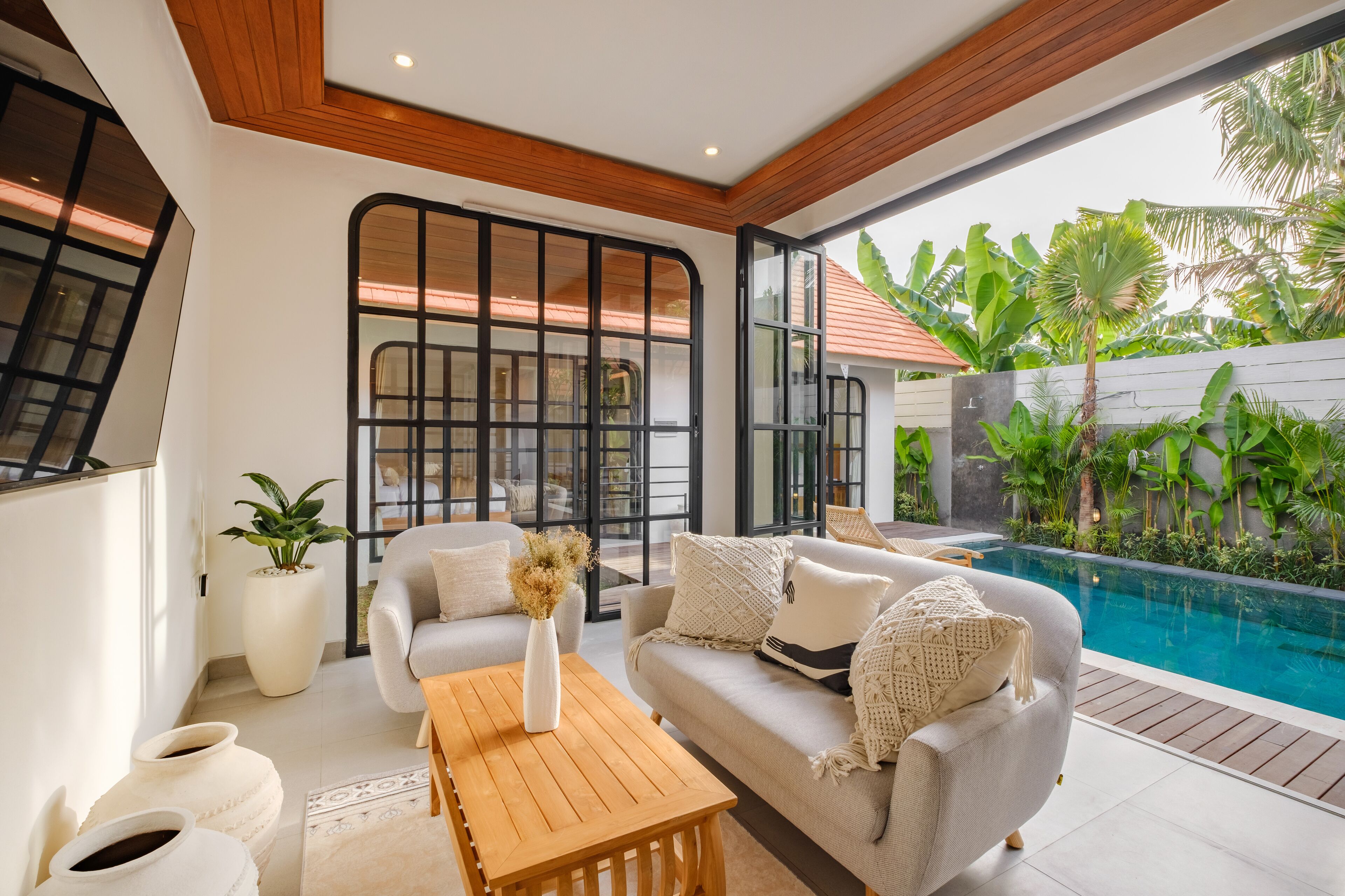 A modern living room with a sofa, coffee table, and potted plants.