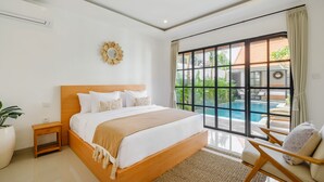 Une chambre avec un grand lit, une petite table de chevet, une plante en pot et une vue sur une piscine, visible à travers une porte-fenêtre coulissante.