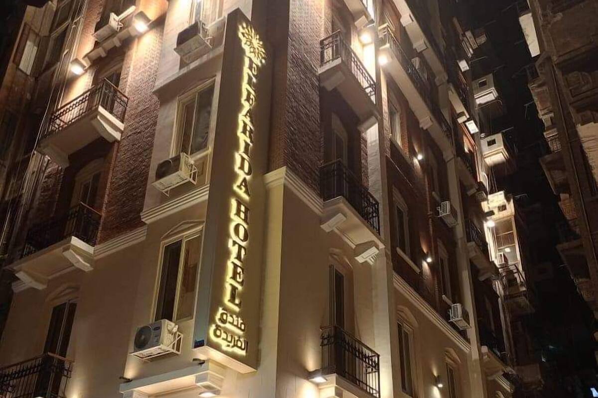 A hotel with a prominent vertical sign displaying its name in multiple languages.