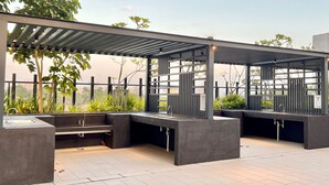 An outdoor patio area with a pergola, built-in seating, and a water feature.