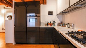 Una cocina moderna con refrigerador de acero inoxidable, horno y estufa a gas.