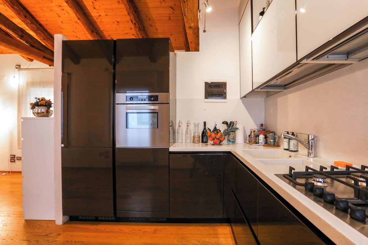 A modern kitchen with a stainless steel refrigerator, oven, and gas stove.