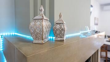 Two decorative vases on a marble countertop with blue LED lights.