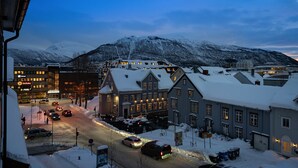 A snow-covered town with buildings and a mountain in the background.