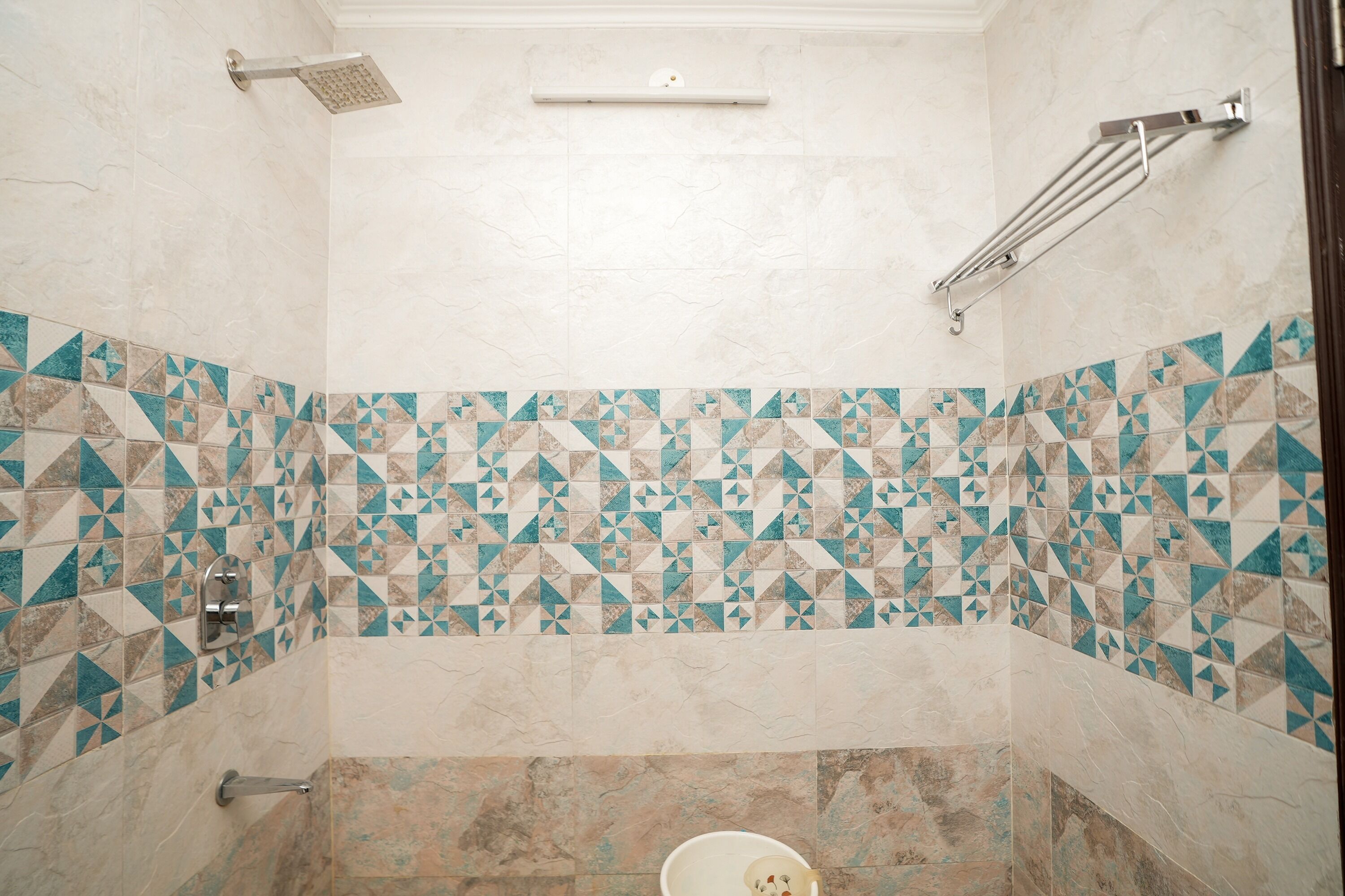 A bathroom with a shower, a toilet, and a towel rack.
