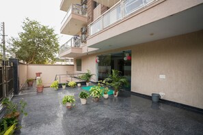 Enjoy the serene outdoor space with lush greenery and vibrant flowers, surrounded by the building's sleek design.