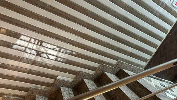A staircase with a metal handrail and a wooden floor.