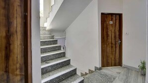 A staircase leading to a wooden door marked with the number 107. - Hotel Grand (New Delhi)