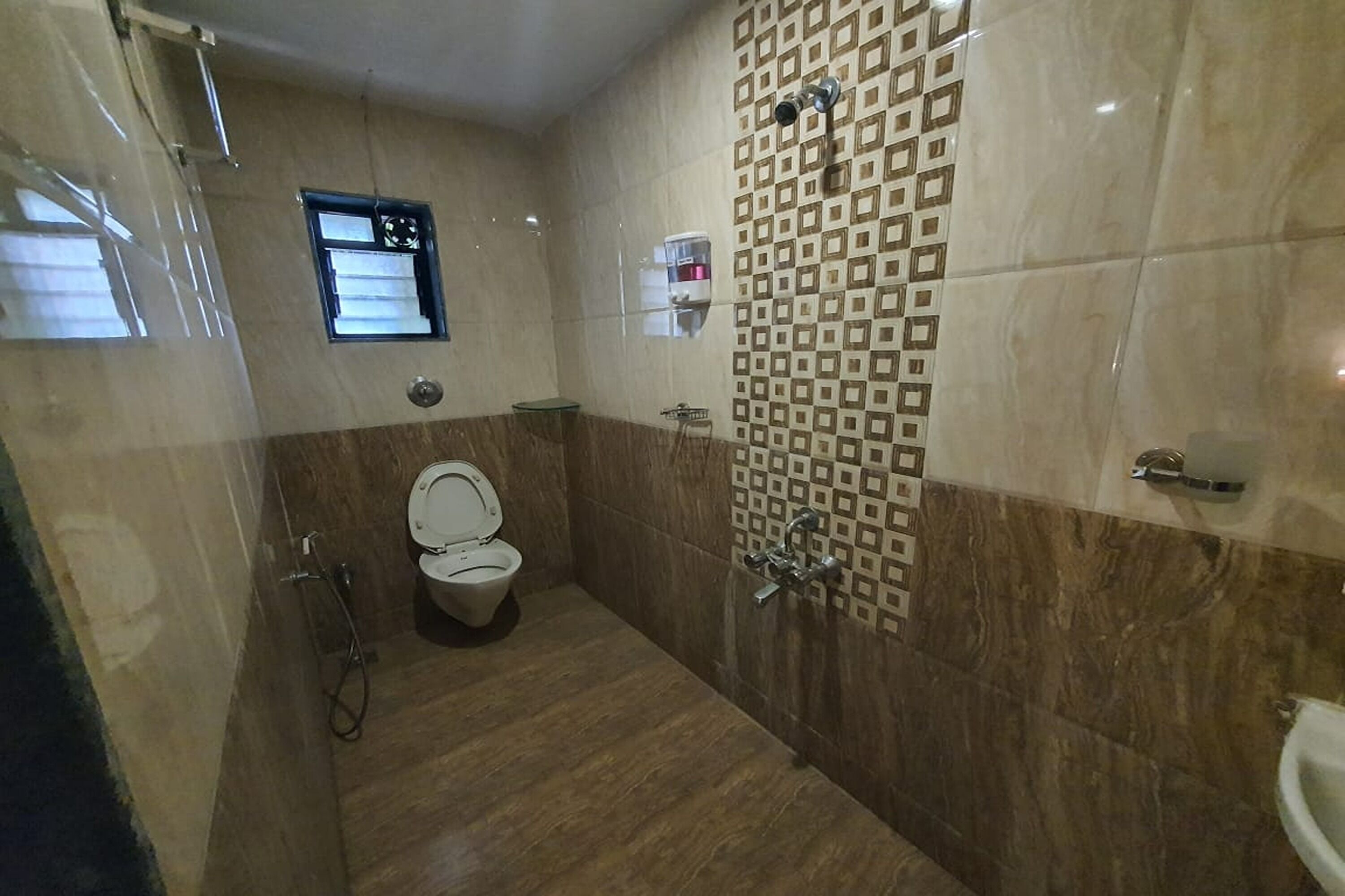 A bathroom with a toilet, a shower, and a sink.