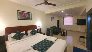 A hotel room with a bed, a desk, a chair, a TV, and a ceiling fan. - Silver Leef (Wai)