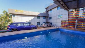 A hotel named 'SILVER Lee Furniture Shaved Room' with a swimming pool, cars parked outside, and a colorful fence. - Silver Leef (Wai)